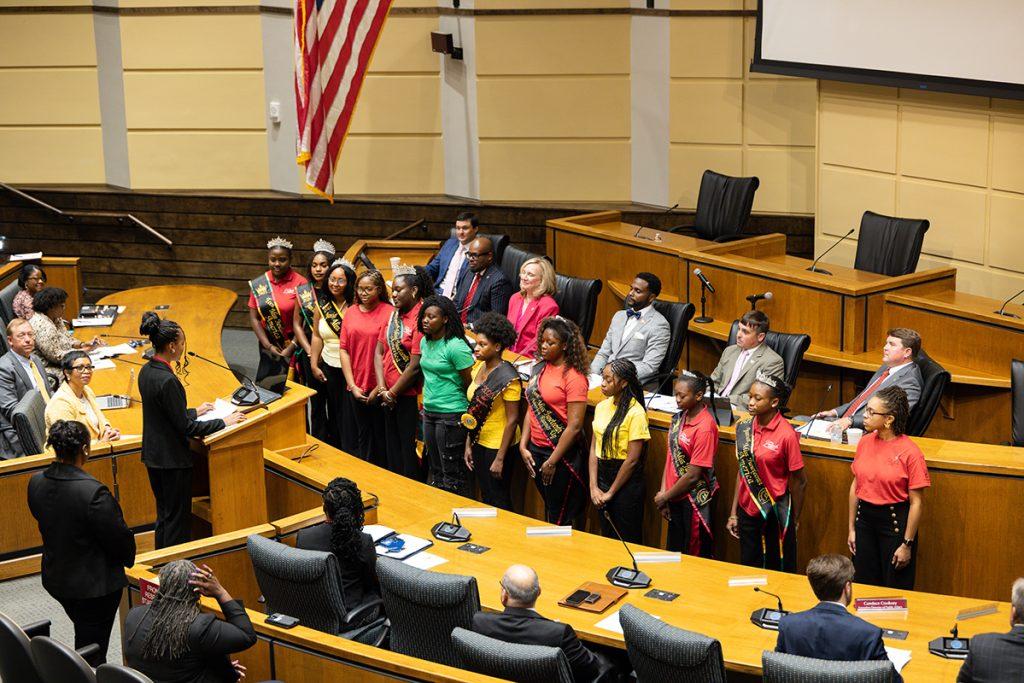 Miss Juneteenth America representatives standing before Mobile city leaders during the fifth-anniversary proclamation recognition.